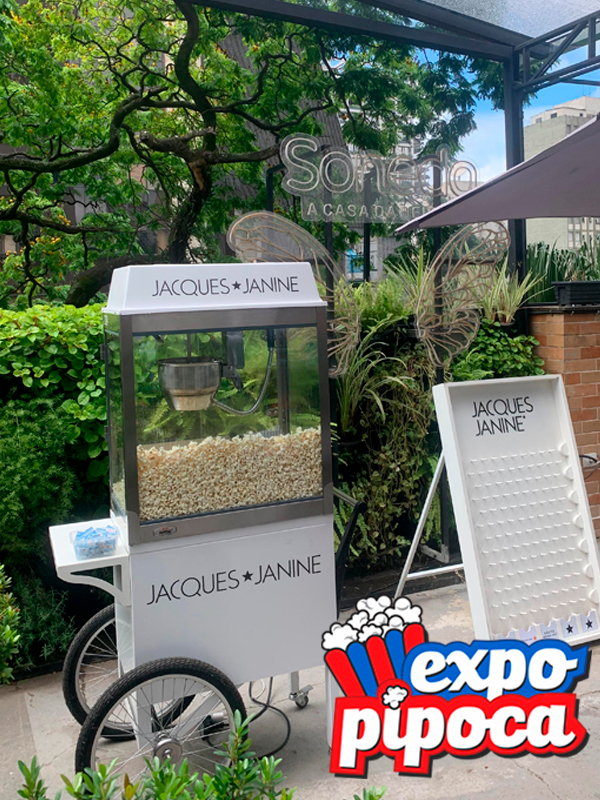 Carrinho de pipoca com frente personalizada com logo da empresa em evento corporativo em São Paulo.